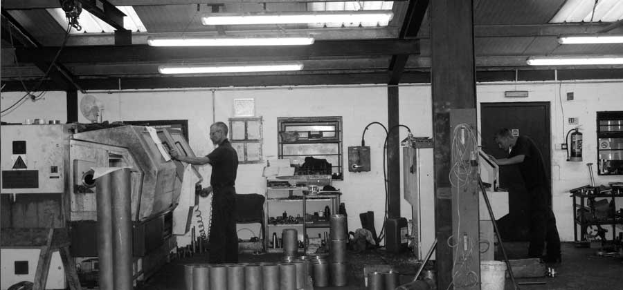 Workmen being photographed while working in the workshop